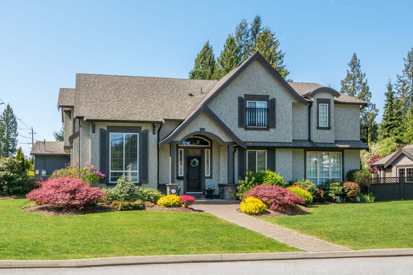 Luxury house with beautiful landscaping on a sunny day. Home exterior.