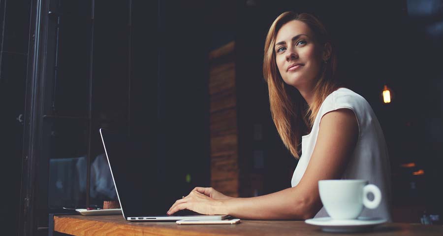 female working on laptop at coffee shop