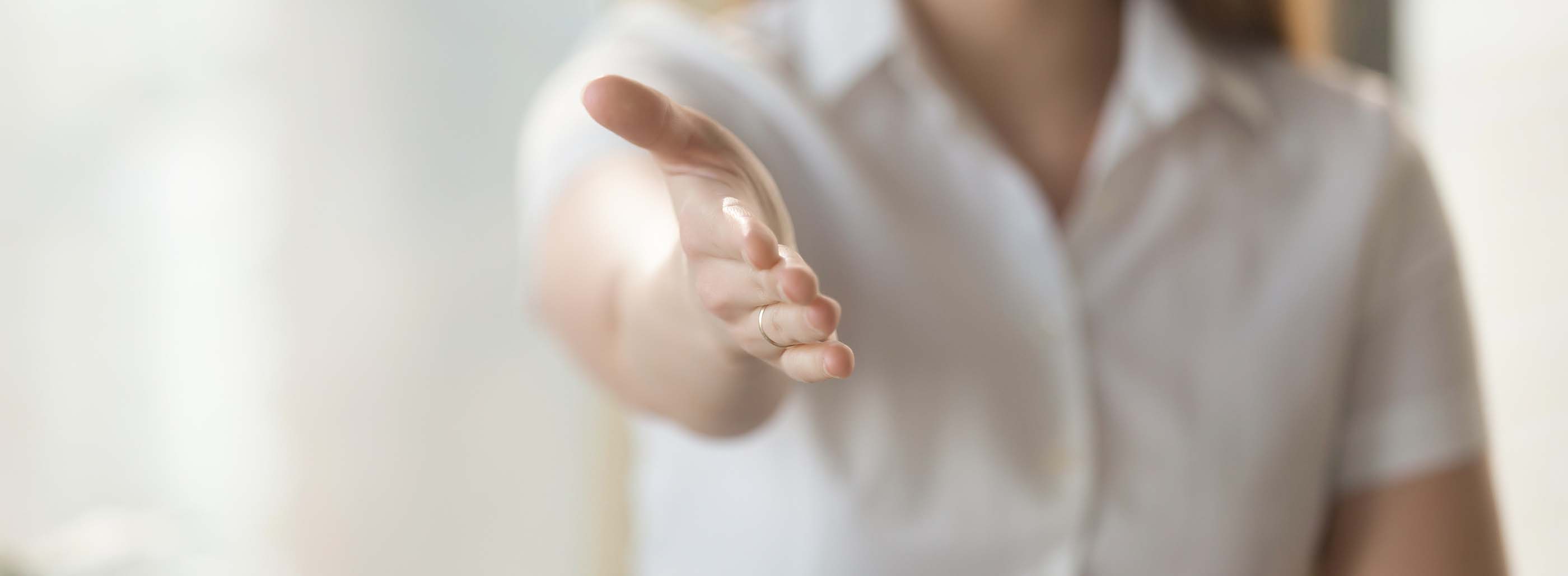 Female helping hand extended at camera for handshake,