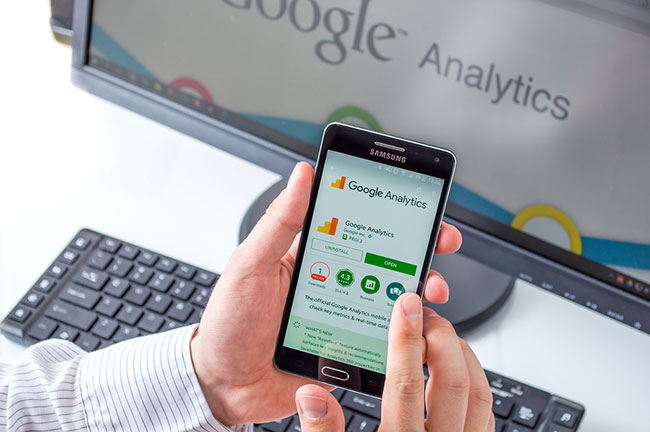 Desktop and phone with screens showing Google Analytics.