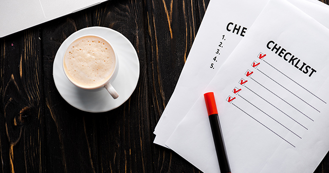 Image of a checklist on a desk next to a cup of coffee